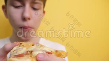 披萨。 快乐的<strong>青</strong>少年男孩<strong>吃</strong>一片披萨的概念。 十几岁的男孩饿了，<strong>吃</strong>了一片比萨饼的生活方式。 慢动作